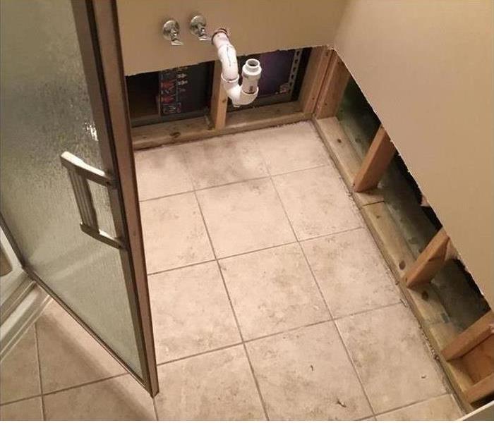 shower door and white tile floor with sewage damage