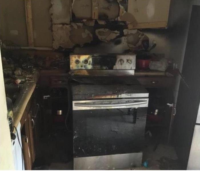 kitchen stove and over covered in soot from fire damage