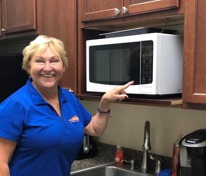 Diane Whittles standing next to the microwave